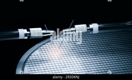 Close-up study of the test sample of the transistor microchip under a microscope in the laboratory. Equipment for testing chips. Production automation Stock Photo