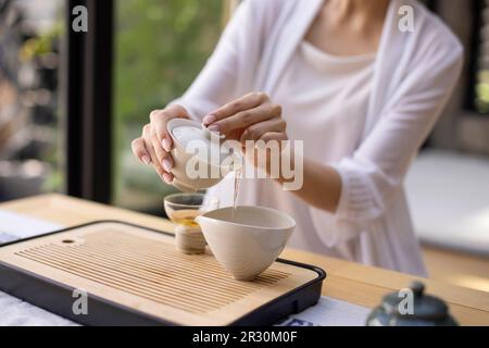 Elegant young Chinese woman drinking tea in tea room Stock Photo