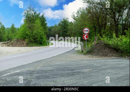 Turn signs and no overtaking sign on country road. Right turn sign. Road signs. Stock Photo