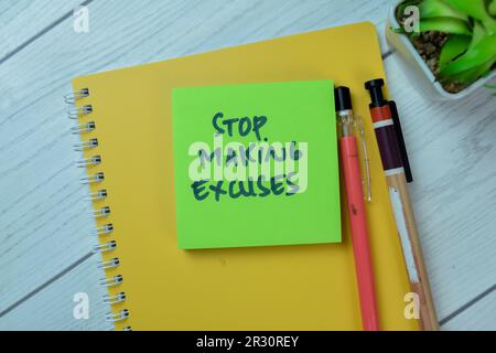 Concept of Stop Making Excuses write on sticky notes isolated on Wooden Table. Stock Photo
