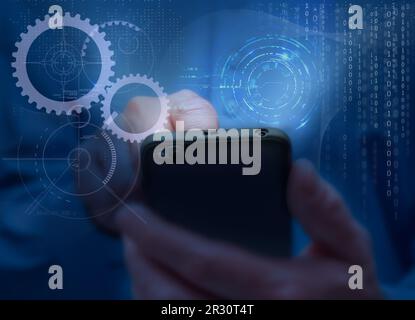 Man in blue shirt holds mobile phone. Symbols and icons of mobile internet, social networks, emails, cloud storage, multimedia services and so on. Mob Stock Photo