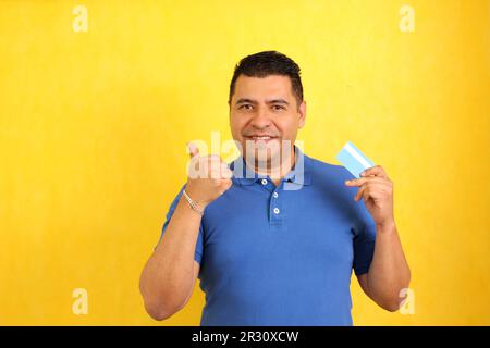 Forty-year-old dark-skinned Latino adult man shows his credit card to make payments, online purchases for months without interest Stock Photo