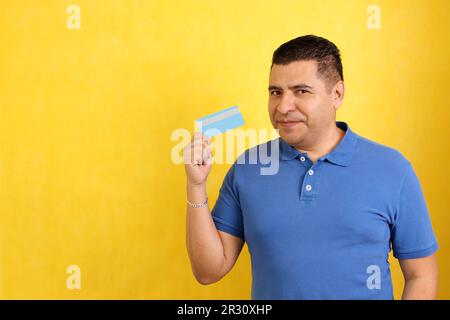 Forty-year-old dark-skinned Latino adult man shows his credit card to make payments, online purchases for months without interest Stock Photo