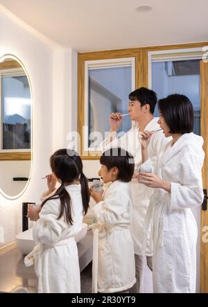 Happy young Chinese family brushing teeth Stock Photo