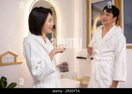 Happy young Chinese couple brushing teeth Stock Photo