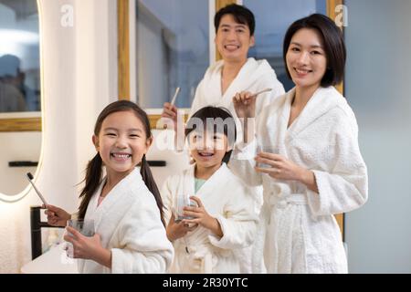 Happy young Chinese family brushing teeth Stock Photo