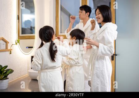 Happy young Chinese family brushing teeth Stock Photo