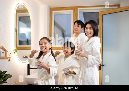 Happy young Chinese family brushing teeth Stock Photo