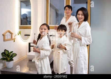 Happy young Chinese family brushing teeth Stock Photo