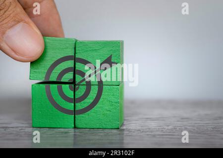Hand placing wooden cubes with target board icon. Copy space for text. Business target, objective, goal concept Stock Photo