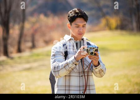 Young man taking photos outdoors Stock Photo