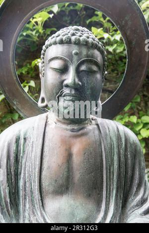 A Buddha type sculpture at Samares Manor botanic garden in St Clements, Jersey, Channel Islands. Stock Photo