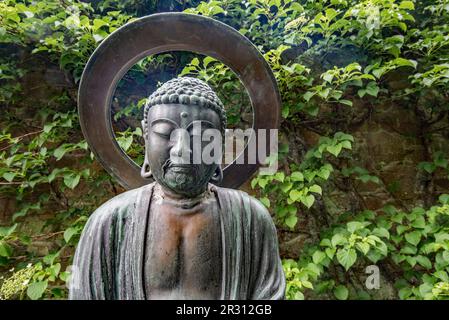 A Buddha type sculpture at Samares Manor botanic garden in St Clements, Jersey, Channel Islands. Stock Photo