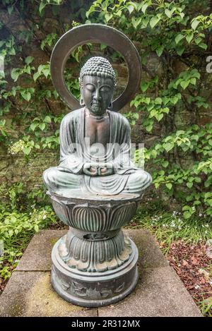 A Buddha type sculpture at Samares Manor botanic garden in St Clements, Jersey, Channel Islands. Stock Photo