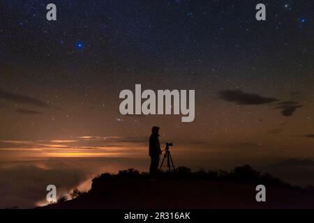 Man photographing the starry sky after sunset Stock Photo