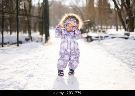 Baby girl wear child snowsuit on a sunny frosty winter day Stock Photo Alamy