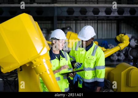 Engineer work at robotic arm factory. Technology and engineering concept. Stock Photo