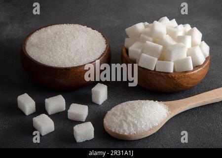 Cube sugar and granulated sugar on black background,closeup Stock Photo