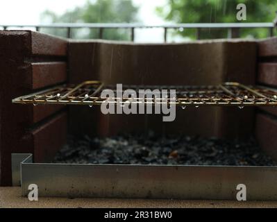 Empty barbecue grill with grid under rain outdoors, closeup Stock Photo