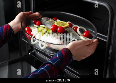 Glass baking tray with raw sea bass fish and ingredients in oven, closeup  Stock Photo - Alamy