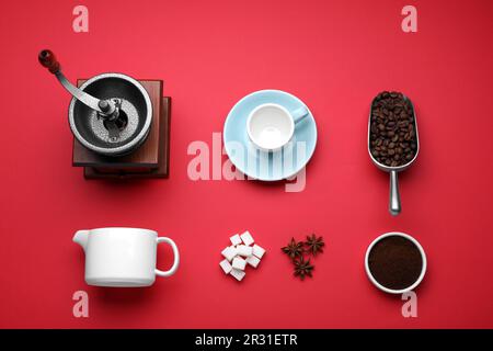 Flat lay composition with vintage manual coffee grinder and beans on red background Stock Photo