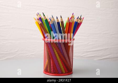 Many colorful pencils in holder on white background Stock Photo