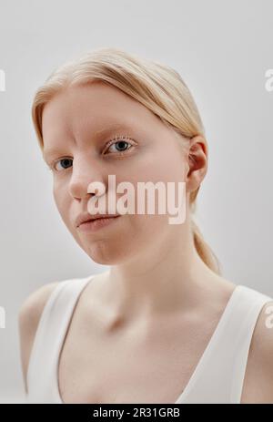 Vertical fashion portrait of ethereal girl with tattooes standing