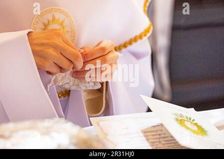 children's hands hold a rosary in a transparent bag for the first communion. Catahese Stock Photo