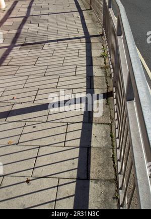 railings and shadows on the pavement Stock Photo