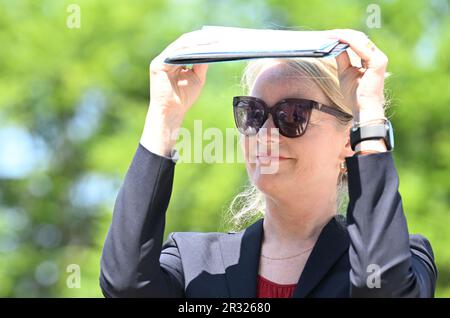 22 May 2023, Baden-Württemberg, Sulzbach-Laufen: Thekla Walker (Bündnis 90/Die Grünen), Minister of the Environment of Baden-Württemberg, holds a file in front of her face as a sunshade during a tour of a wind turbine construction site. According to the organizers, the future wind farm will be an example of the turnaround in the expansion of renewable energies, as the approval process for the plant was completed within eight months, from application to issuance by the Schwäbisch Hall District Office. The new wind farm will operate from summer 2024 with a total of seven wind turbines. Photo: Be Stock Photo