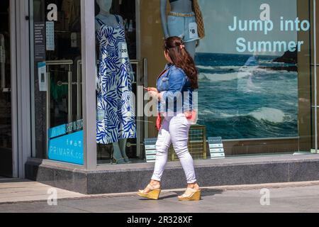 Jump inot Summer fashions in Southport, Merseyside. UK Weather   May 2023 Shops, shoppers shopping on a warm sunny day in the town centre.  Monday (May 22) will see temperatures hit the mid 20s as much warmer weather awaits the country over the next fortnight. Met Office forecasters announced that Sunday was the hottest day the UK had been all year and now mercury levels are set to climb even higher after a balmy start to the week. Stock Photo