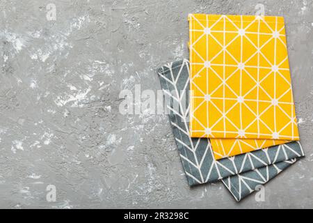 top view with yellow empty kitchen napkin isolated on table background. Folded cloth for mockup with copy space, Flat lay. Minimal style. Stock Photo