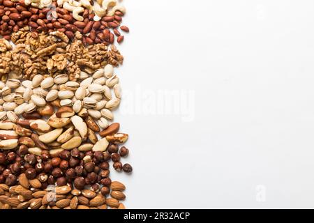 different nuts frame background. Close up, top view, flat lay with vopy space. Walnut, pistachios, almonds, hazelnuts and cashews. Stock Photo