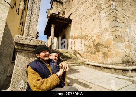 lugareños frente a la iglesia parroquial católica de San Lorenzo Mártir, siglo XVI, Garganta De La Olla, valle del Tiétar,La Vera, Cáceres, Extremadura, Spain, europa. Stock Photo