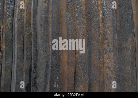 Basalt pillars in a quarry. Natural basalt rock columns closeup texture. Abstract natural background or texture. Stock Photo
