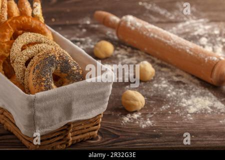 Various types of bread in a basket with small balls of dough and rolling pin. Close up. Copy space Stock Photo