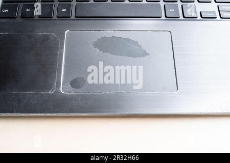 worn out touchpad of old laptop close up on table Stock Photo