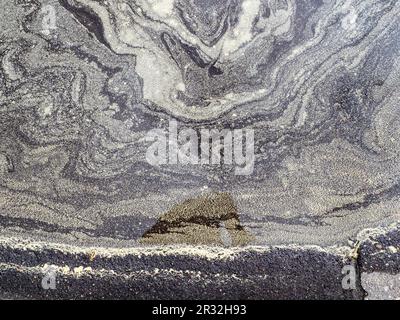 top view of birch pollen on surface of rain puddle on asphalt road Stock Photo