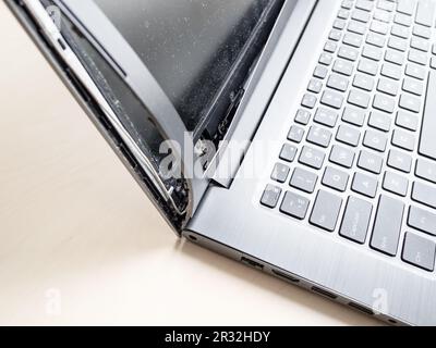 side view of broken screen frame of old laptop close up on table Stock Photo