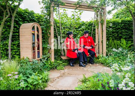 London, UK. 22nd May, 2023. The London Square Community Garden, Sanctuary Garden, Chelsea Pensioners playing on the garden chess boards and trying out the swing seat, enjoying the communal spirit with volunteers from the roof garden on a high- rise estate in Battersea which inspired the design. Monday at the 2023 Chelsea Flower Show. Credit: Guy Bell/Alamy Live News Stock Photo