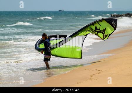 A kitesurfer holding on to the kite on the beach in Mui Ne, Vietnam. Stock Photo