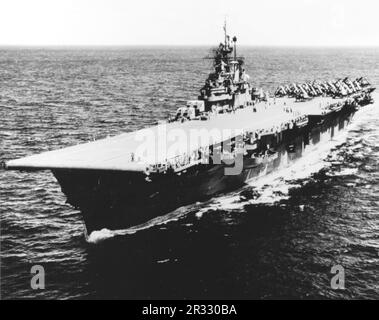 The US Essex Class carrier USS Bunker Hill  (CV-17) at sea in 1945. The ship was badly damaged by two kamikaze strikes in one minute on 11 May 1945 at Okinawa. he strike caught fully fuelled and armed planes on deck and started very dangerous fires. Though heavily damaged the ship did not sink and returned to the USA for repair. The ship was decommissioned in 1966 and scrapped in 1973. Stock Photo