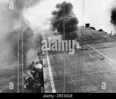 View of the attack of a Japanese A6M5 kamikaze suicide plane aboard the U.S. Navy escort carrier USS Suwannee (CVE-27) off the Philippines on 25 October 1944: the kamikaze's 250 kilogram bomb has just exploded between flight and hangar decks and fire billows out. When Japan was facing defeat in late 1944 it chose to destroy US ships with suicide bombings, known as Kamikaze.These attacks were a potent physical and psychological weapon and sunk a total of 47 ships at a cost of more than 3000 pilots and planes. By late 1944 the US Navy was large enough that the losses were insignificant and they Stock Photo