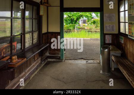 Hyogo, Japan - May 15, 2023: Wooden waiting room at historic unmanned station leads to empty platform Stock Photo