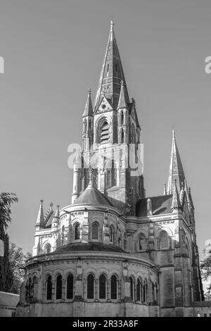 The tall Gothic spire of an Anglican church in Cork, Ireland. Neo-Gothic Christian religious architecture. Cathedral Church of St Fin Barre, Cork - On Stock Photo