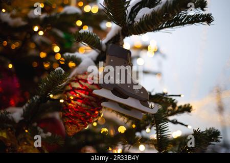 beautiful multi-colored toys on a Christmas tree against the background of lights and snow Stock Photo