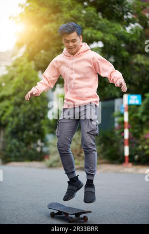 Young man performing stunt on skateboard Stock Photo