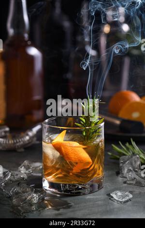 Cocktail Old Fashioned Negroni. The astringency of the whiskey is leveled by sugar, and the herbal tincture and smoking rosemary add flavor and origin Stock Photo