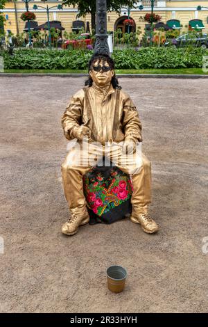 A silent motionless theatrical street performer in a gold painted costume in Esplanadi park in Helsinki, Finland. Stock Photo