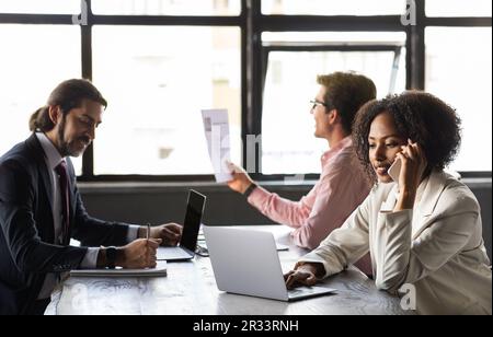 International team of employees working on project together, office interior Stock Photo